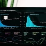 A laptop screen showcasing sports analytics with various graphs and statistics in a sleek, dark color scheme.