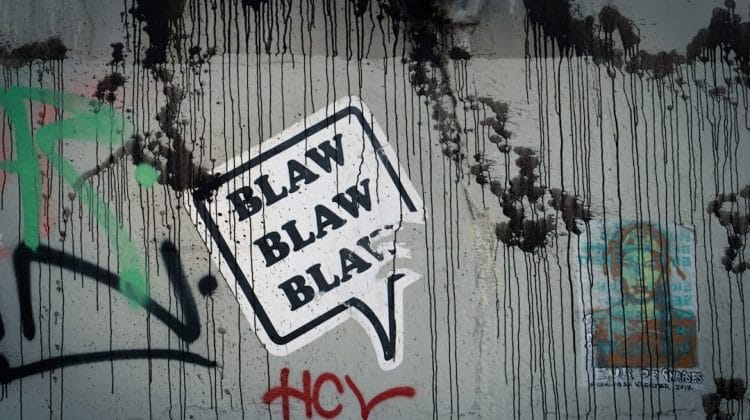 Graffiti on a wall with a speech bubble saying "BLAW BLAW BLAW," where black drips and colorful tags dance around unpopular sports opinions.