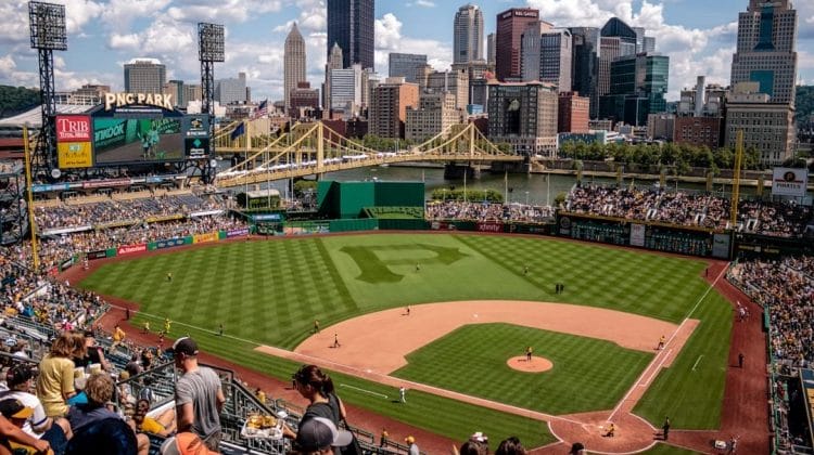 Aerial view of PNC Park during a baseball game, with the Pittsburgh skyline and bridge in the background, captures the essence of America's pastime alongside the evolution of baseball statistics.