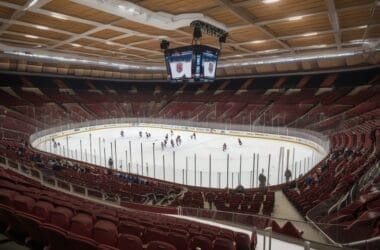 From the stands, witness an NHL Fan Experience in this empty hockey arena as teams face off on the ice. The energy is palpable even without a crowd, offering a unique perspective on the sport.