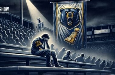 A person in a Chicago Bears jersey sits in an empty stadium, head in hands, under a large banner with a roaring bear and a trophy. The dimly lit scene conveys a somber mood as the stadium seats in the background remain mostly unoccupied.